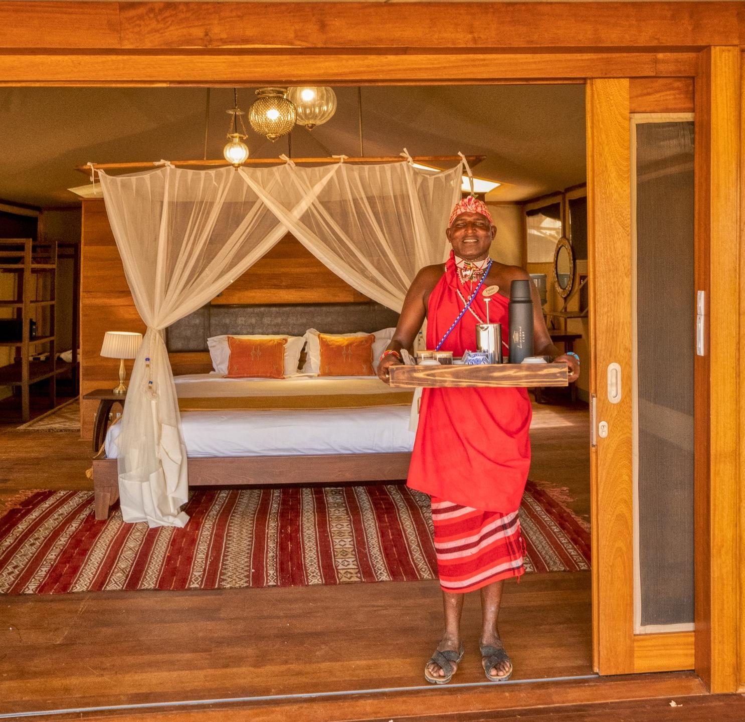Maasai staff member serving coffee at a luxury tented suite